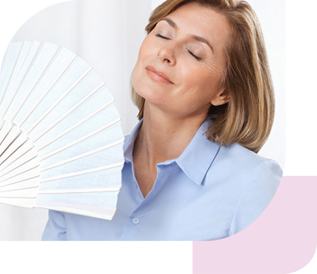 Eine Frau mittleren Alters fächert sich Luft zu als Zeichen der Hitzewallungen in den Wechseljahren